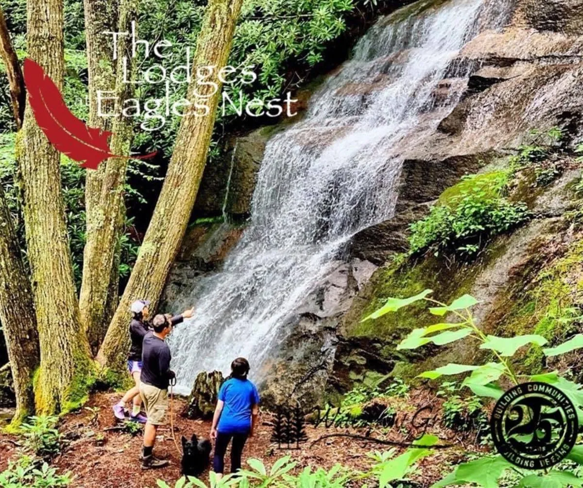 This image features hikers and a dog making their way along a forested trail toward a picturesque waterfall. The lush greenery, flowing water, and presence of people actively exploring the outdoors embody the adventure and natural beauty described in the section.